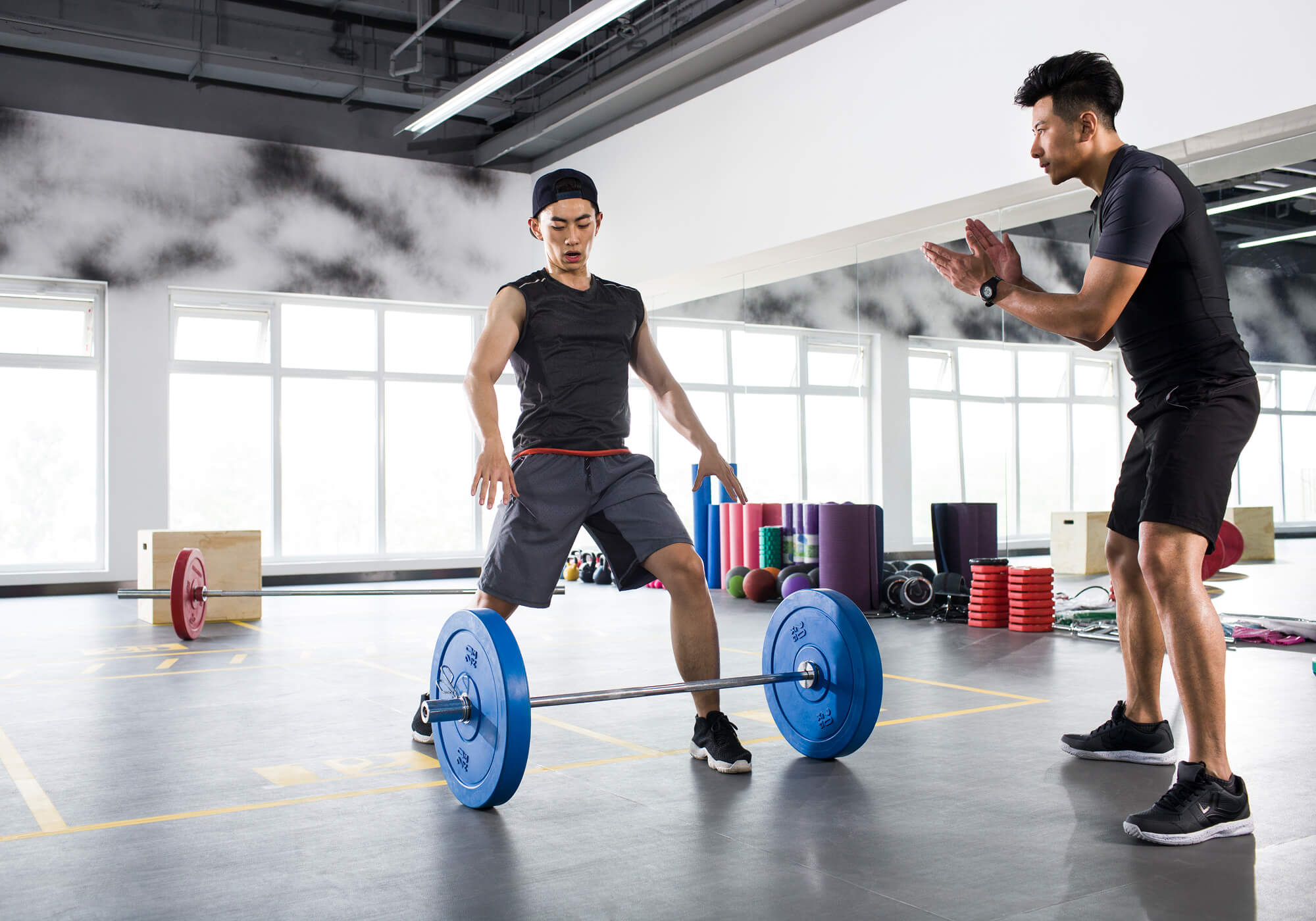 young-man-working-with-trainer-at-gym-TGLXSZA.jpg